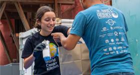 Callie, HIP 2025 Cohort member, handing food out for their World Central Kitchen DC activation